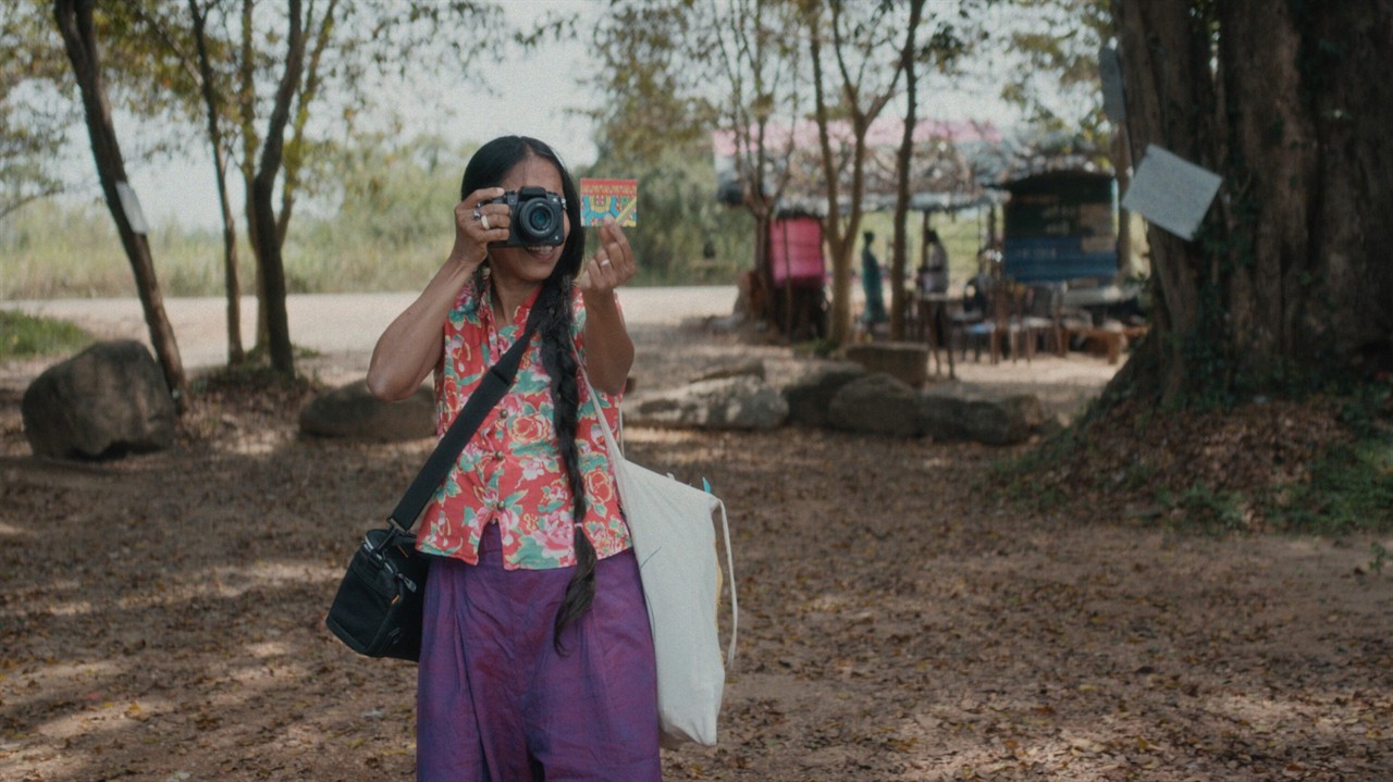 Arachchige taking a photograph of a small card